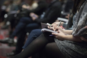 Reporters and journalists take notes on a press release for tech firm.